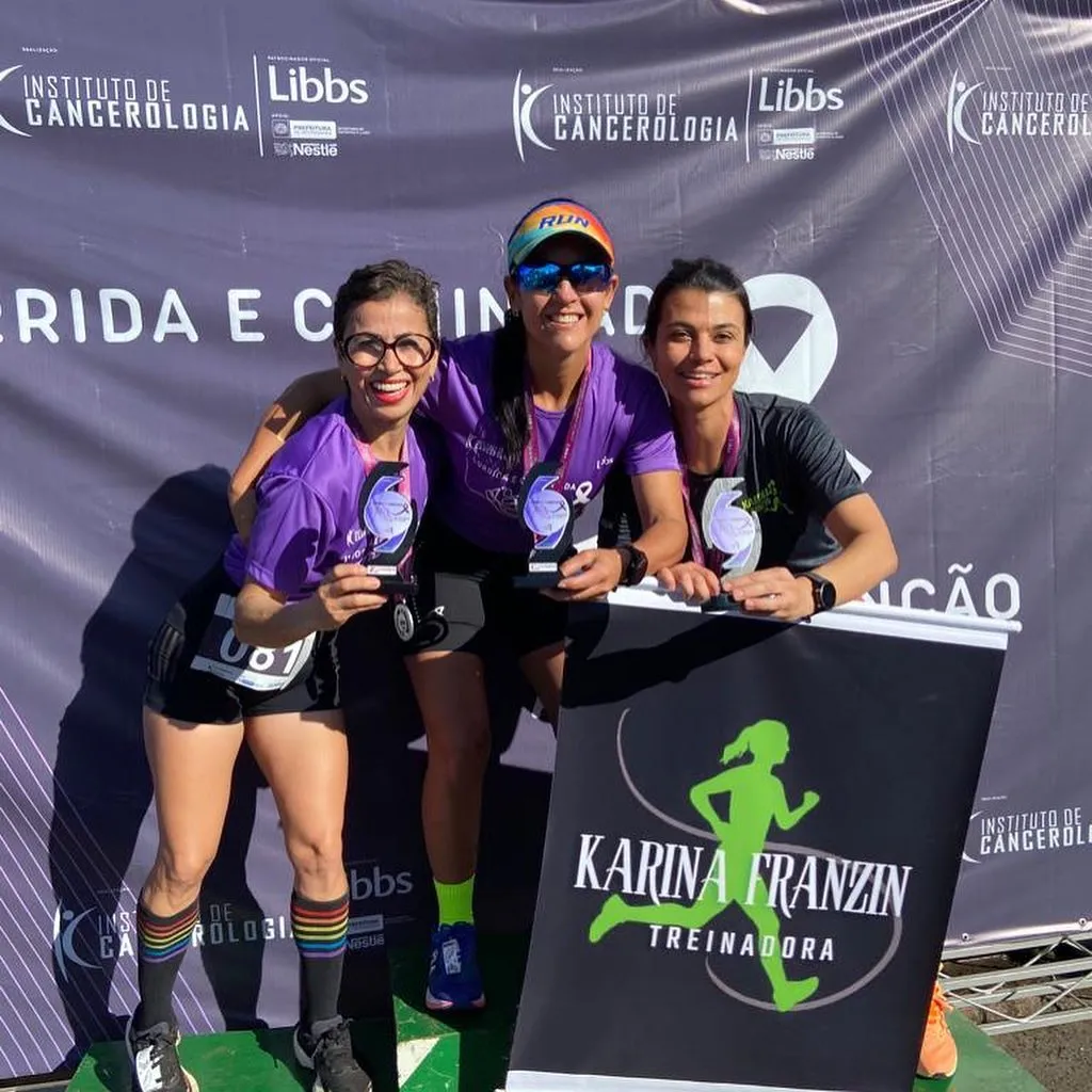 Aluna no pódio celebrando resultado com assessoria esportiva Karina Franzin